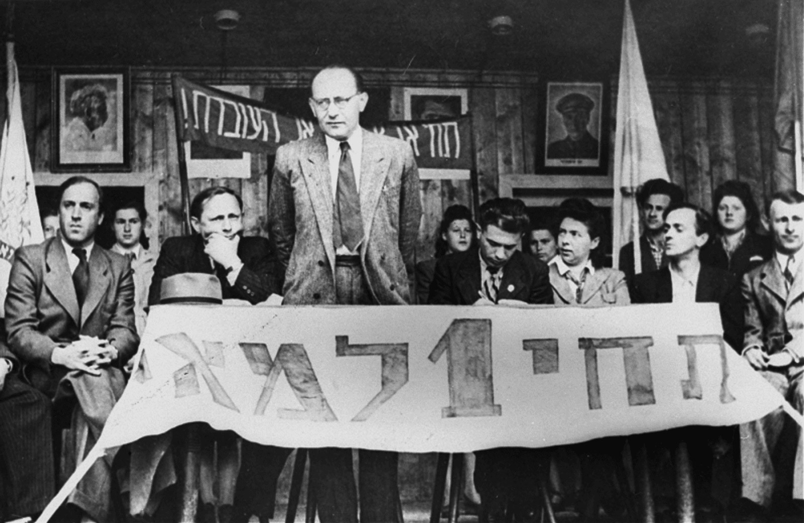 May 1st, holiday of the working class: Chaim Yahil as emissary of the Jewish Agency with survivors of Nazi persecution (“Displaced Persons”) in the DP Camp of München-Neu-Freimann (1946 / 1948).  The Jewish Agency organized Jewish immigration to Palestine.  Photo: Jack Sutin / United States Holocaust Memorial Museum, courtesy of Saul Sorrin. der NS-Verfolgung („Displaced Persons“) im DP-Camp München-Neu-Freimann (1946 / 1948). Die Jewish Agency organisierte die Einwanderung nach Palästina.  Foto: Jack Sutin / United States Holocaust Memorial Museum, courtesy of Saul Sorrin
